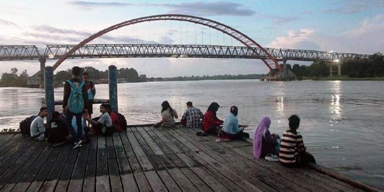 Warga Kota Palangkaraya, Kalimantan Tengah, menikmati senja di kafe tepi Sungai Kahayan, Jumat (10/4/2015). Keindahan alam, termasuk potensi wisata susur sungai, menjadi salah satu potensi wisata Palangkaraya. Namun, pengelolaan potensi itu belum optimal.