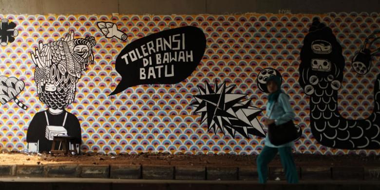 Mural berjudul Toleransi di Bawah Batu karya seniman Eko Nugroho di dinding kolong Tol Bintaro, Jakarta, Selasa, (12/11/2013). Gambar mural ini merupakan bagian dari Jakarta Biennale ke-15 yang mengambil tema Siasat.