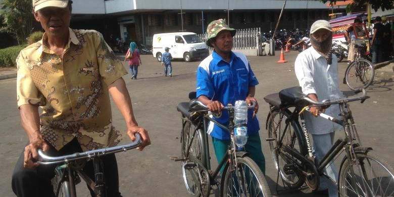 Tiga pengojek sepeda ontel menunggu calon penumpang keluar dari Stasiun Jakarta Kota, Jumat (11/9/2015).
