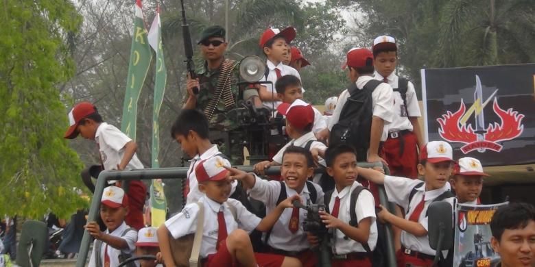 Beberapa siswa sekolah dasar berebut naik kendaraan tempur milik TNI AD yang dihadirkan dalam pameran alutsista yang digelar di kampus Universitas Sriwijaya, Ogan Ilir, Sumatera Selatan, Senin (12/10;/2015).