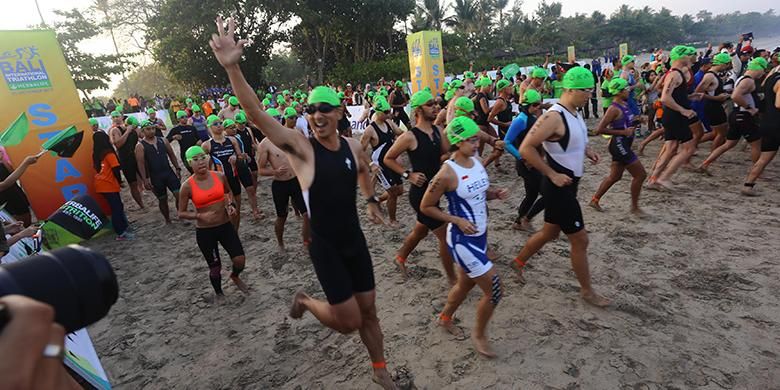Peserta Herbalife Bali International Triathlon (HBIT) 2015 berlari melakukan start untuk melakukan sesi renang di kawasan Pantai Jimbaran, Bali, Minggu (25/10/2015).