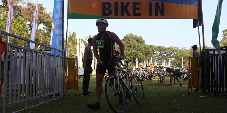 Peserta Herbalife Bali International Triathlon (HBIT) 2015 bersepeda menuju jalur yang telah ditentukan di kawasan Pantai Jimbaran, Bali, Minggu (25/10/2015).