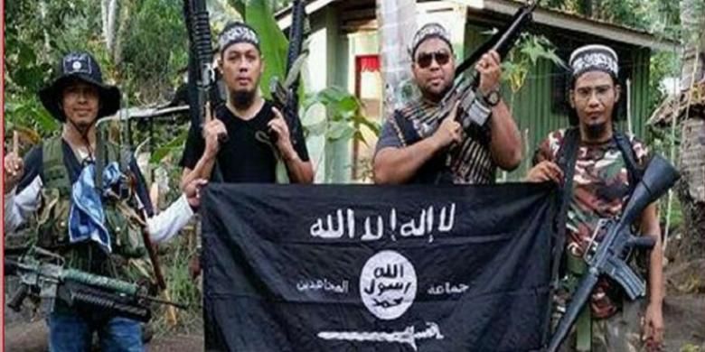 Dari kiri pejuang Abu Sayyaf, Mahmud Ahmad, Muhammad Joraimee Awang Raimee dan Muamar Gadafi, berfoto dengan bendera ISIS