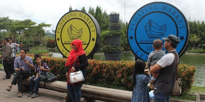 Pengunjung Floating Market Lembang berfoto di depan replika koin yang jadi mata uang Floating Market Lembang, Selasa (22/12/2015).