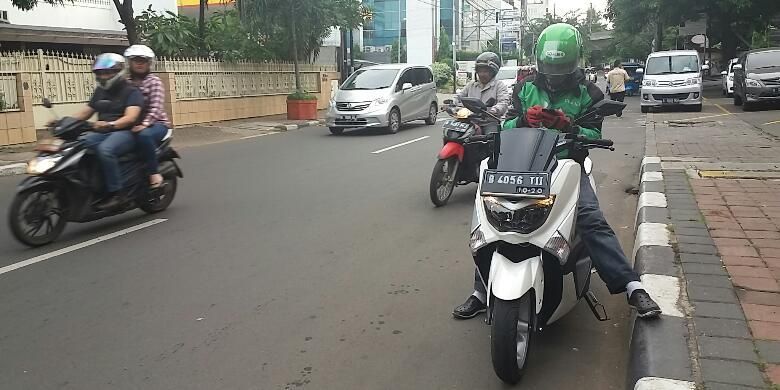 Pengendara ojek online, Hermawan (30) yang menggunakan motor Yamaha NMAX saat berada dikawasan Cikini, Jakarta Pusat pada Minggu (27/12/2015). Motor jenis itu jarang digunakan oleh kebanyakan pengojek, sebab harganya mencapai dua puluhan juta.