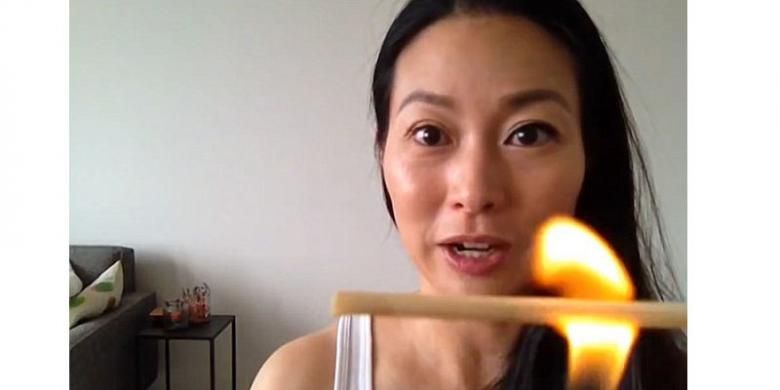 Soerang beauty vlogger memperagakan cara menggunakan sumpit yang dibakar untuk melentikkan bulu mata. 