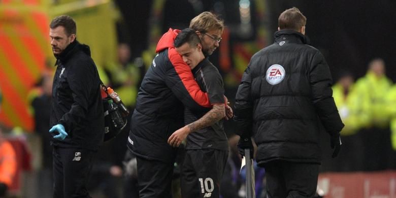 Manajer Liverpool, Juergen Klopp (merah) memberikan pelukan saat Philippe Coutinho ditarik keluar karena cedera pada babak pertama partai kontra Stokie City, Selasa (5/1/2015).