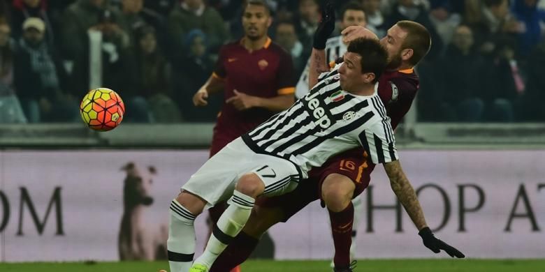 Striker Juventus, Mario Mandzukic, berebut bola dengan gelandang AS Roma, Daniele De Rossi, saat kedua tim bertanding pada lanjutan Serie A di Juventus Stadium, Minggu (24/1/2016).