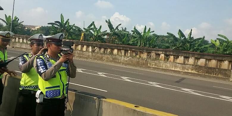 Petugas kepolisian dari Direktorat Lalu Lintas Polda Metro Jaya melakukan uji coba pembatasan kecepatan dengan menggunakan Speed Gun di tol yang mengarah ke bandara pada KM 25-900, Jakarta, Sabtu (12/3/2016).