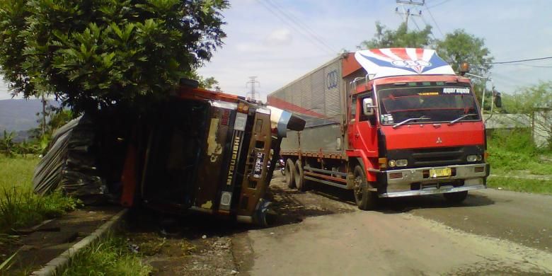 Sebuah truk terguling di Jalan Pembangunan, Kecamatan Cibeureum, Sukabumi, Jawa Barat, Kamis (28/4/2016). 