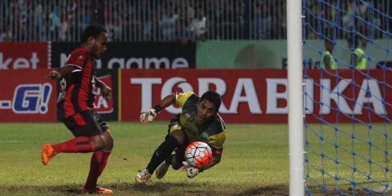 Aksi penyerang mungil Persipura, Lukas Mandowen jelang membobol gawang Persela yang dikawal kiper Choirul Huda (kuning) di Stadion Surajaya, Lamongan, Senin (23/5/2016).
