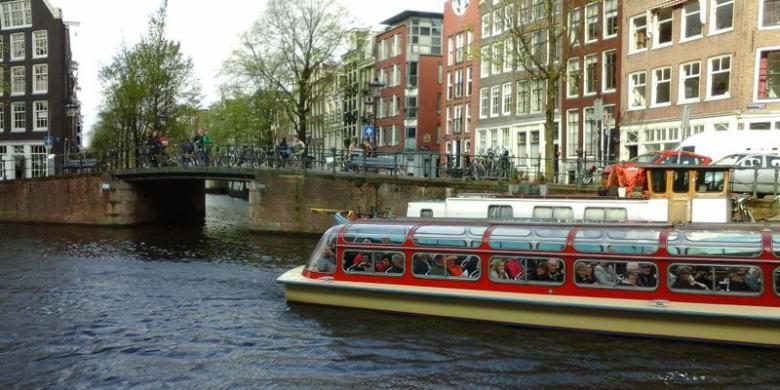 Wisata air di kanal Amsterdam. Kanal-kanal ini begitu terawat dan menjadi obyek wisata.