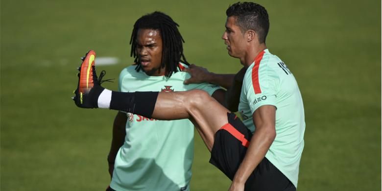 Penyerang Portugal Cristiano Ronaldo (kanan) melakukan peregangan otot dan dibantu gelandang muda Portugal, Renato Sanches, dalam sesi latihan persiapan Piala Eropa 2016 di Cidade do Futebol (Football City) di Oeiras, Lisabon, Minggu (5/6/2016).