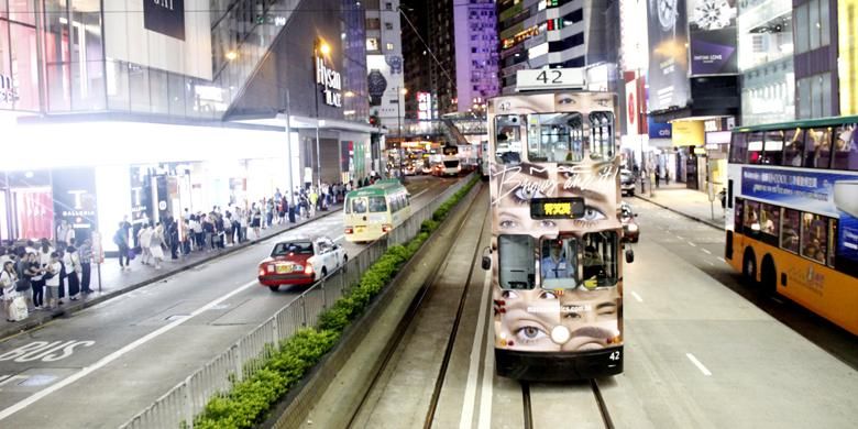 Moda transportasi umum di Hongkong yakni trem dan bus berjalan berdampingan di sudut jalan area Causeway Bay, Hongkong, Rabu (15/6/2016) malam. 