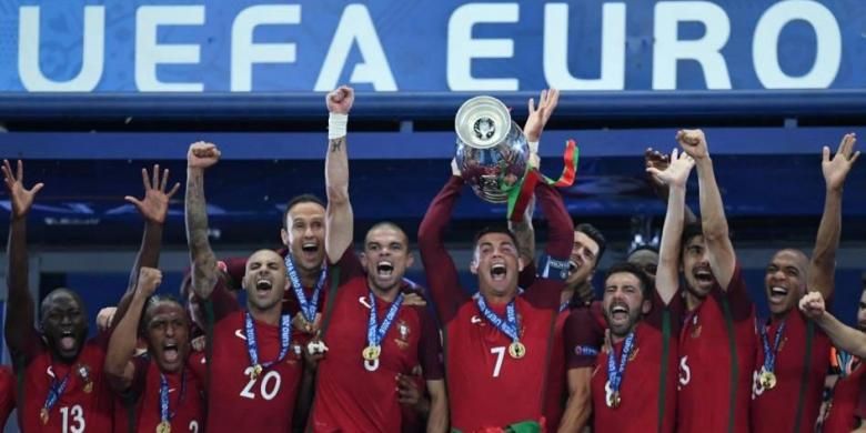 Penyerang Portugal Cristiano Ronaldo (tengah) mengangkat trofi saat merayakan kemenangan bersama timnya yang memenangi final Piala Eropa Euro 2016, Senin (11/7/2016). Portuga mengalahkan Perancis 1-0 saat final di Stade de France.
