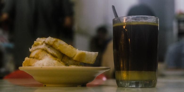 Sepiring roti panggang bersisipkan butter dan segelas kopi butter dari kopitiam Heap Seng Leong.