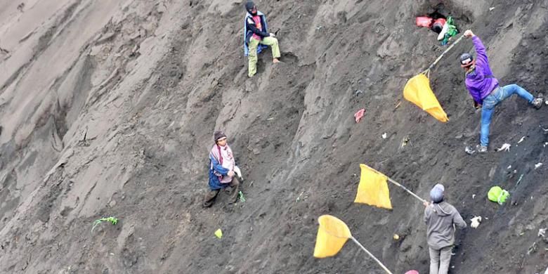 Warga luar Suku Tengger menangkap dengan jaring sesaji yang dilemparkan warga Tengger ke dalam kawah Gunung Bromo dalam puncak perayaan Yadnya Kasada di Kecamatan Sukapura, Kabupaten Probolinggo, Jawa Timur, Kamis (21/7/2016). Perayaan Yadnya Kasada sebagai ritual penghormatan leluhur dan wujud terima kasih warga Tengger atas hasil bumi tetap dilakukan walaupun Gunung Bromo berstatus Waspada.