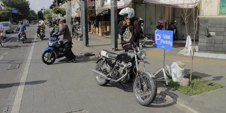 Pengendara motor berhenti di depan plang besi Valet Parking di Pasar Gede Hardjonagoro, Solo, Jawa Tengah, Jumat (22/7/2016) siang. Layanan Valet Parking mulai hadir di dekat pintu masuk Pasar Gede pada tanggal 5 Januari 2016.