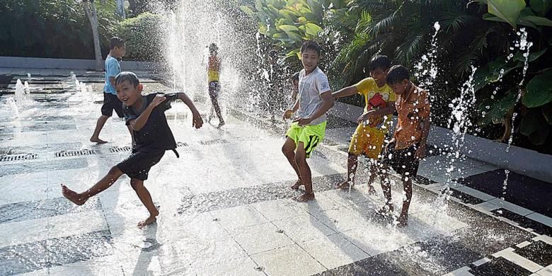 Air mancur di depan  Balai Kota Surabaya menjadi tempat bermain anak-anak, seperti terlihat Sabtu (23/7/2016).