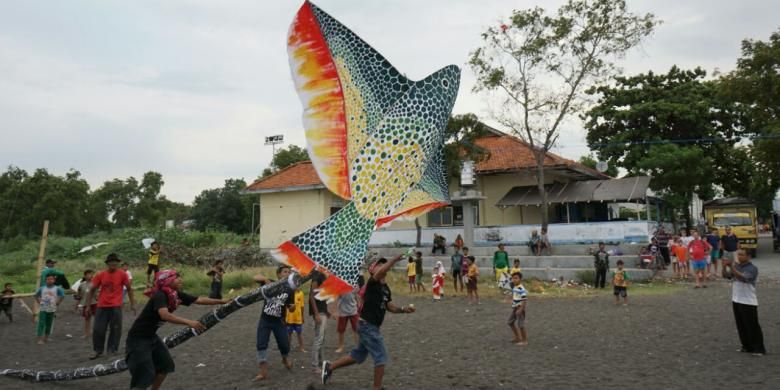 Peserta Festival Layang Layang sedang menerbangkan layang-layang di Pantai Boom, Banyuwangi, Jawa Timur,  Minggu (7/8/2016).