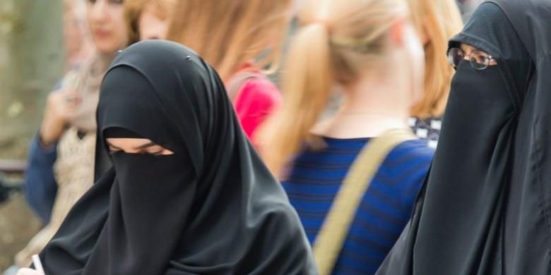 Dua perempuan Muslim Jerman mengenakan niqab di satu sudut kota Frankfurt.