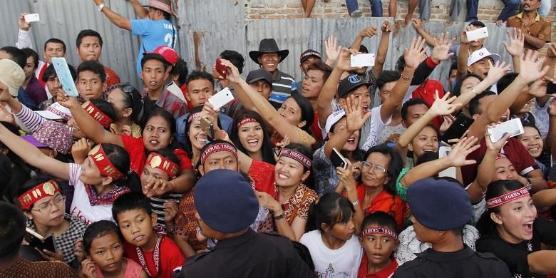 Masyarakat berteriak histeris saat rombongan Karnaval Kemerdekaan Pesona Danau Toba yang diikuti Presiden Joko Widodo dari Soposurung, Balige, Toba Samosir, Sumatera Utara, Minggu (21/8/2016). Perayaan Hari Ulang Tahun (HUT) ke-71 RI tahun ini dipusatkan di Danau Toba, Sumatera Utara dengan tajuk Karnaval Kemerdekaan Pesona Danau Toba. Acara ini berlangsung di dua tempat yakni Parapat (Simalungun) dan Balige (Toba Samosir).