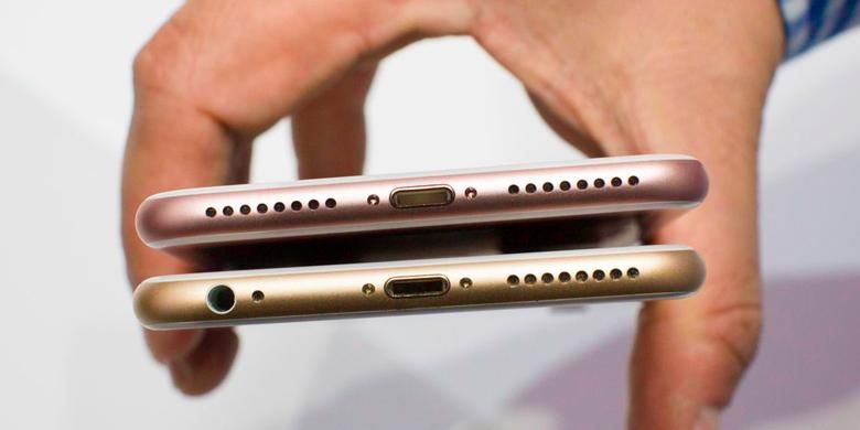 iPhone 7 (atas) tidak memilki port audio 3,5 milimeter, sedangkan iPhone 6S (bawah) masih memilikinya