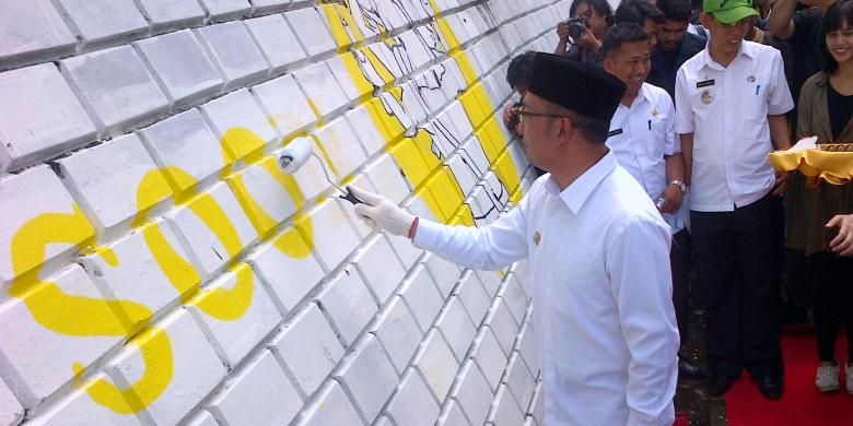 Wali Kota Bandung Ridwan Kamil saat mengecat tembok di Jalan Babakan Siliwangi sebagai tanda pembukaan pembuatan lukisan mural sepanjang 476 meter, Selasa (13/9/2016). KOMPAS.com/DENDI RAMDHANI 