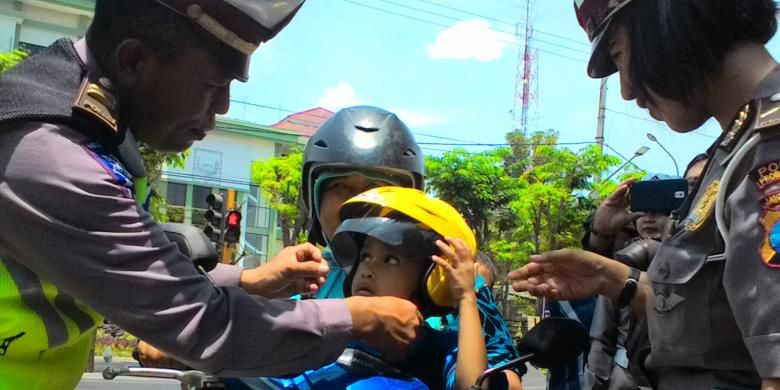 Seorang anak mendapatkan helm gratis dari Polisi dalam operasi simpatik di Kabupaten Probolinggo. 