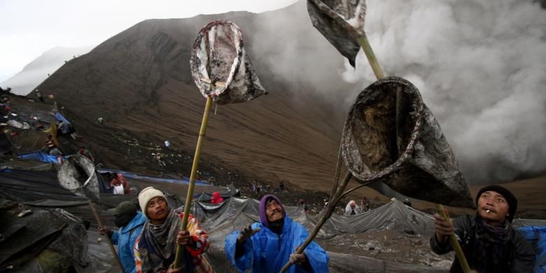 Beberapa warga Suku Tengger mencoba menangkap sesaji yang dilemparkan ke dalam Kawah Bromo oleh penganut Hindu Tengger, saat Yadnya Kasada digelar pada 20-21 Juli 2016.