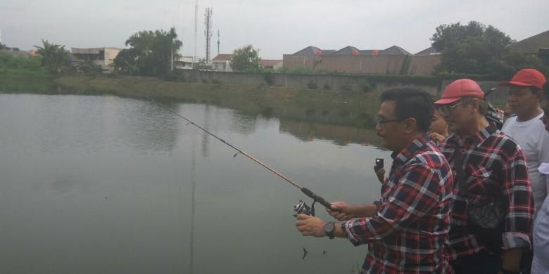 Calon wakil gubernur DKI Jakarta Djarot Saiful Hidayat memancing ketika meninjau Waduk Rawa Lindung di Petukangan Selatan, Pesanggrahan, Jakarta Selatan, Selasa (29/11/2016).