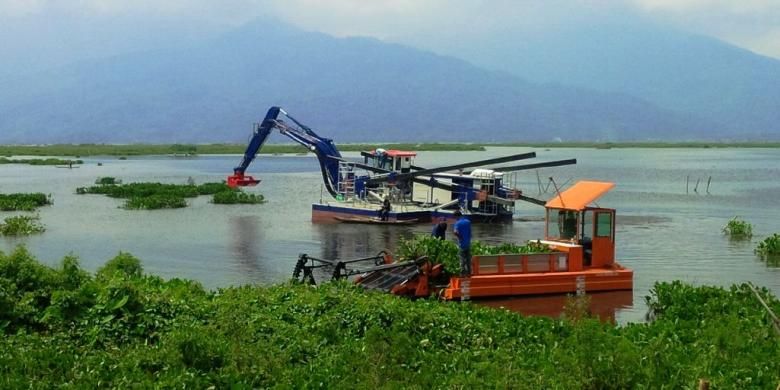 Dua kapal Aquatic tengah bekerja mengambil enceng gondok di perairan Rawapening, tepatnya di dekat dermaga Sumurup, desa Asinan, Bawen, Kabupaten Semarang, Rabu (11/1/2017) siang.