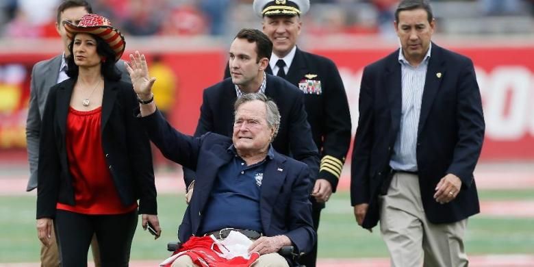 Mantan Presiden AS, George HW Bush, melambaikan tangan kepada kerumunan massa di Stadion TEDECU, November 2015 di Houston, Texas. 