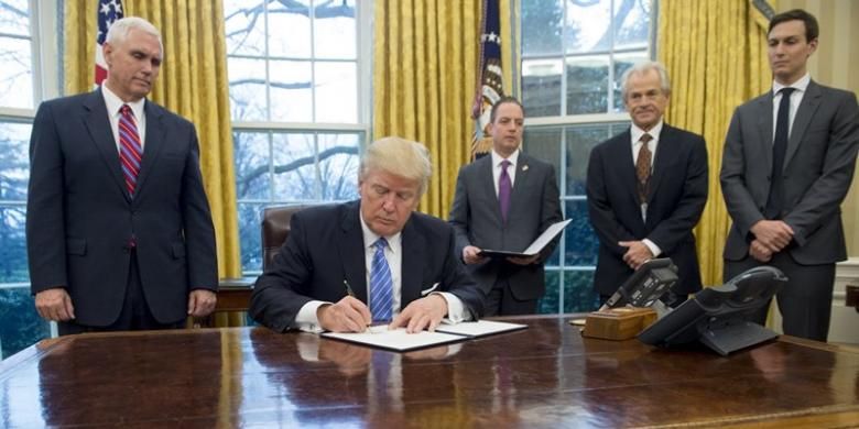 Presiden AS Donald Trump menandatangani sejumlah perintah eksekutif di ruang Oval, Gedung Putih disaksikan wakil presiden Mike Pence, kepala staf Gedung Putih Reince Preibus, dan penasihat senior Jared Kushner.