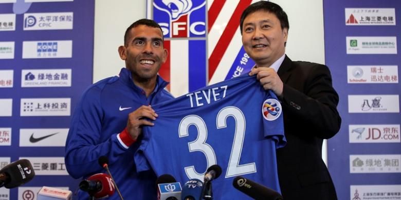 Striker asal Argentina, Carlos Tevez (kiri), berpose dengan jersey klub barunya, Shanghai Shenhua, dalam jumpa pers di Shanghai pada 21 Januari 2017. Tevez melakukan jumpa pers pertamanya bersama Shanghai Shenhua dan dia dilaporkan menjadi pemain dengan gaji tertinggi di dunia.