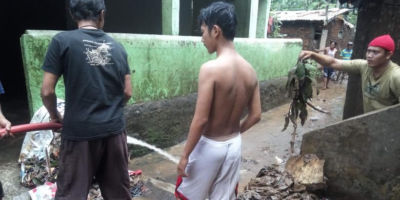 Warga Jalan Masjid Al Makmur sedang membersihkan lumpur dan sampah akibat banjir di kawasan tersebut pada Kamis (16/2/2017).