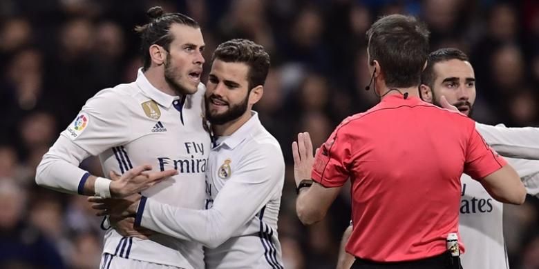 Bintang Real Madrid, Gareth Bale (kiri), berusaha diredam rekan setimnya Nacho Fernandez (dua dari kiri) saat berdebat dengan wasit dalam pertandingan melawan Las Palmas di Santiago Bernabeu pada 1 Maret 2017.  