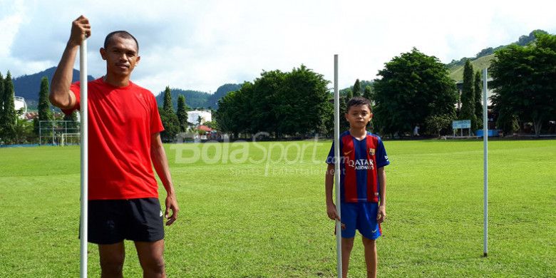 Ricardo Salampessy dan putranya, Reno, di Lapangan PLTA Waena, Jayapura, Papua, Kamis (14/12/2017).