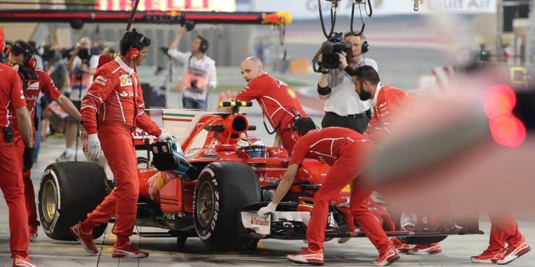 Pebalap Ferrari, Kimi Raikkonen, memasuki garasi timnya saat menjalani sesi latihan bebas GP Bahrain di Sirkuit Internasional Bahrain, Sakhir, Jumat (14/4/2017).
