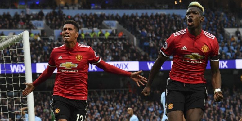 Pemain Manchester United, Chris Smalling (kiri) dan Paul Pogba, merayakan gol ketiga Man United ke gawang Man City pada laga Derbi Manchester di Stadion Etihad, Manchester, pada Sabtu (7/4/2018).