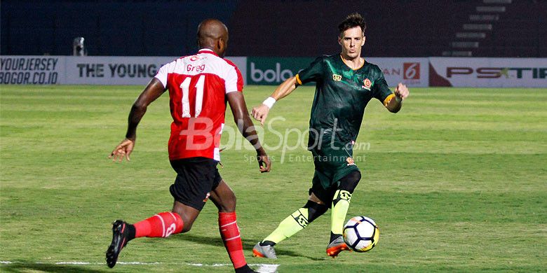 Aksi pemain sayap PS Tira, Mariano Berriex (kanan), berhadapan dengan striker Madura United, Greg Nwokolo, dalam laga lanjutan Liga 1 2018 di Stadion Sultan Agung Bantul, Senin (2/4/2018).
