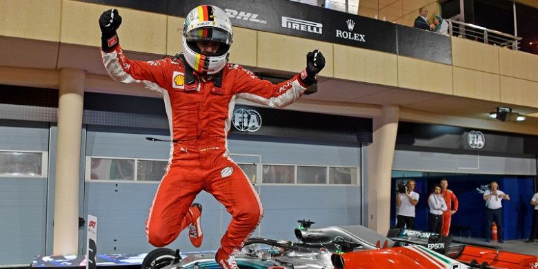 Pebalap Pebalap Ferrari, Sebastian Vettel bereaksi, setelah meraih podium pertama pada GP Bahrain yang berlangsung di Sirkuit Internasional Bahrain, Minggu (8/4/2018).