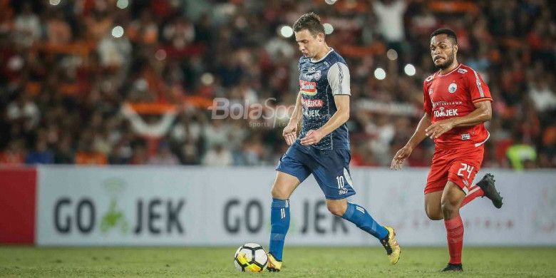 Pemain Arema FC, Balsa Bozovic, diikuti oleh pemain Persija Jakarta, Yan Nasadit, pada laga Liga 1 2018 di Stadion Utama GBK pada Sabtu (31/3/2018).
