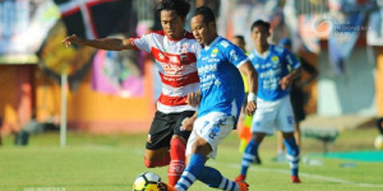 Pemain Madura United, Rendika Rama, sedang merebut bola yang dibawa oleh pemain Persib Bandung, Atep, pada laga yang digelar di Stadion Ratu Pamelingan, Pamekasan, Jawa Timur (4/5/2018)