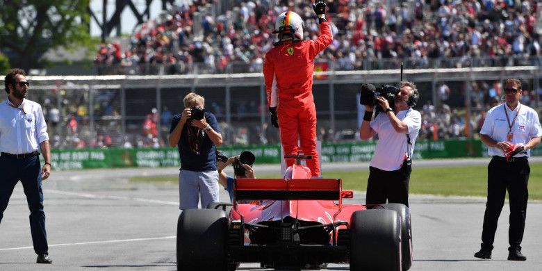 Pebalap Ferrari, Sebastian Vettel, berdiri di atas mobilnya untuk merayakan keberhasilan meraih pole position pada kualifikasi F1 GP Kanada di Sirkuit Gilles-Villeneuve, Montreal, Kanada, Minggu (10/6/2018).
