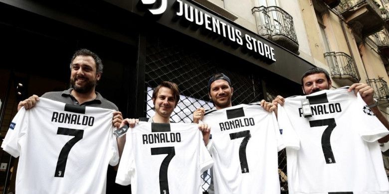 Para pendukung Juventus berpose dengan seragam nomor punggung 7 bertuliskan nama Cristiano Ronaldo di depan gerai Juventus Store di Turin, Senin (10/7/2018)