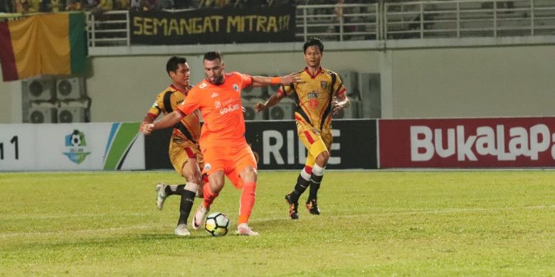 Penyerang Persija Jakarta Marko Simic dijaga ketat pemain Mitra Kukar di Stadion Aji Imbut, Tenggarong, Sabtu (21/7/2018).
