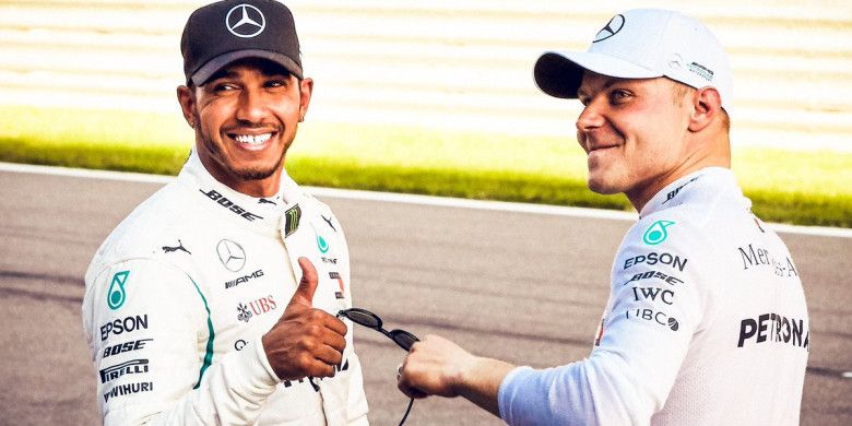 Dua pebalap Mercedes, Lewis Hamilton (kiri) dan Valtteri Bottas (kanan), berpose bersama seusai menjalani sesi kualifikasi di Sochi Autodrom, Rusia, pada Sabtu (29/9/2018).
