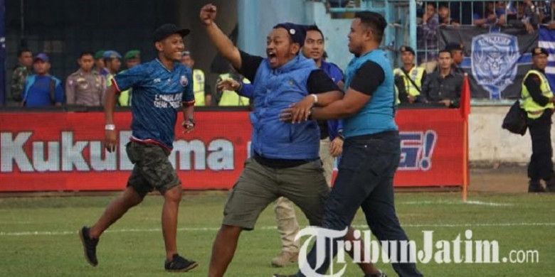 Oknum Aremania sambil berteriak memasuki lapangan Stadion Kanjuruhan, Kepanjeng, Kabupaten Malang, untuk mendatangi pemain Persebaya Surabaya yang sedang berlatih, Sabtu (6/10/2018) sore WIB.
