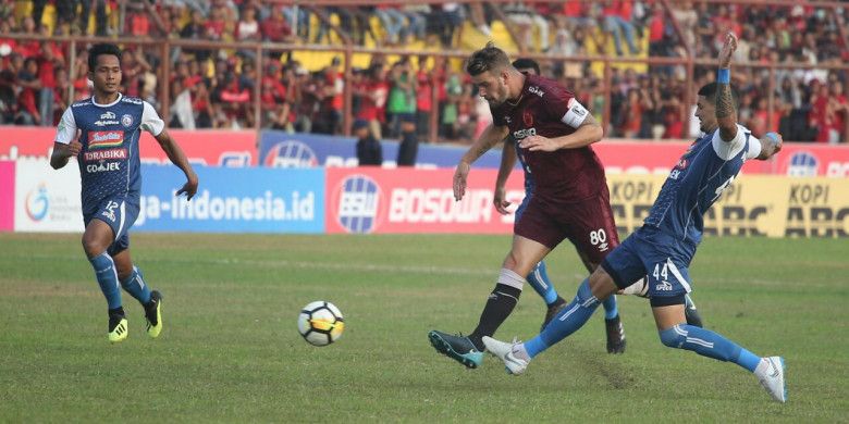 Bek Arema FC, Arthur Cunha disakikan rekan setimnya, Hendro Siswanto (kiri) saat mencoba menghentikan gelandang PSM Makassar, Wiljan Pluim pada lanjutan Liga 1 2018 di Stadion Andi Mattalatta, Kota Makassar, 14 Oktober 2018.
